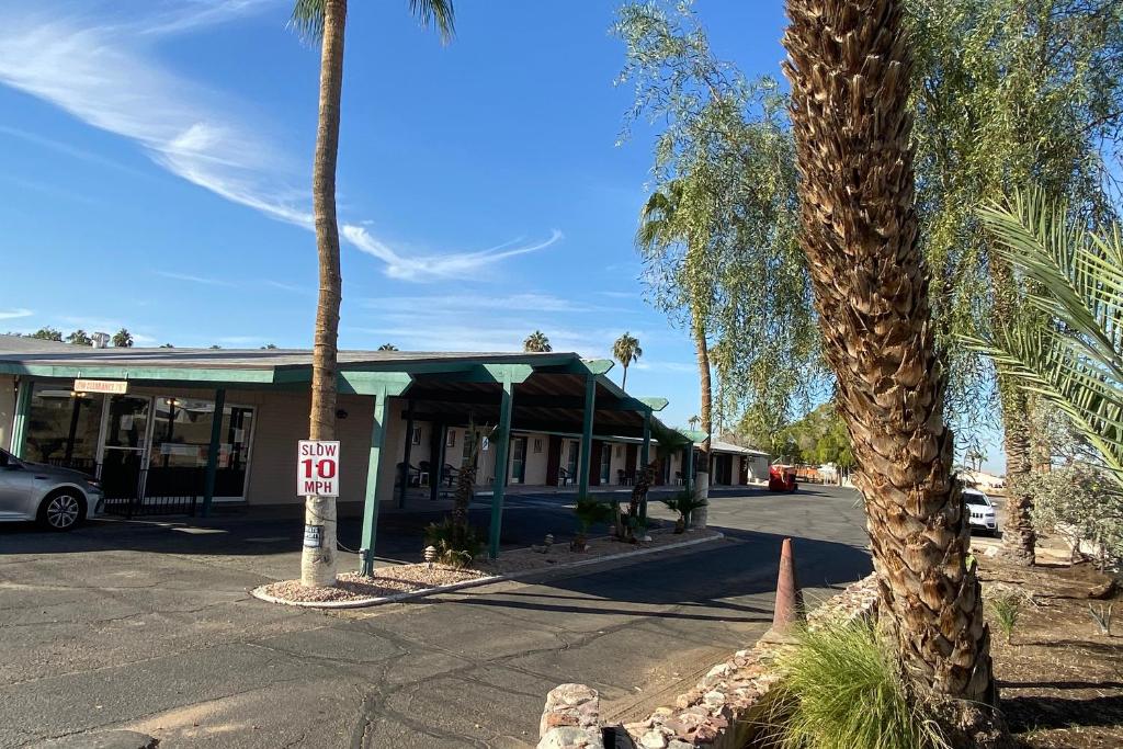 a building with palm trees in front of a street at OYO Hotel Yuma AZ Desert Grove in Yuma