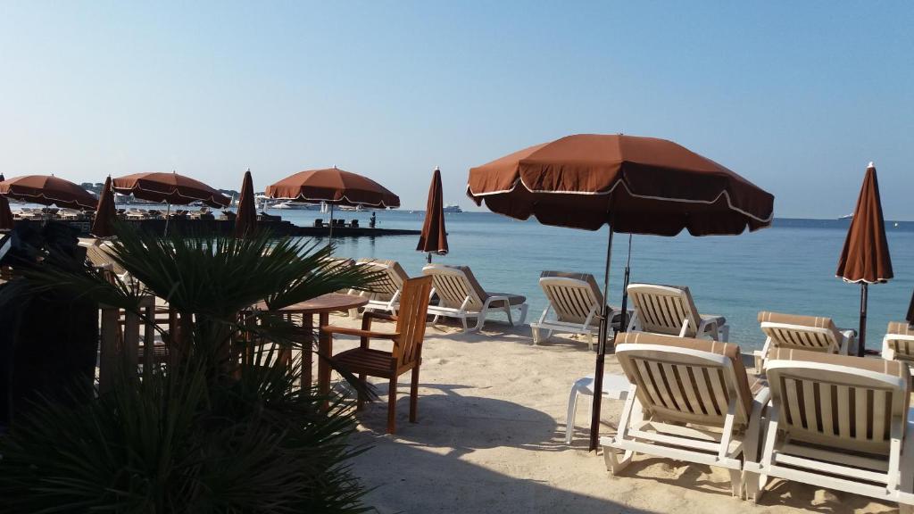 - un groupe de chaises, de tables et de parasols sur une plage dans l'établissement STUDIO 3mn A PIED DE LA PLAGE AVEC TERRASSE, à Antibes