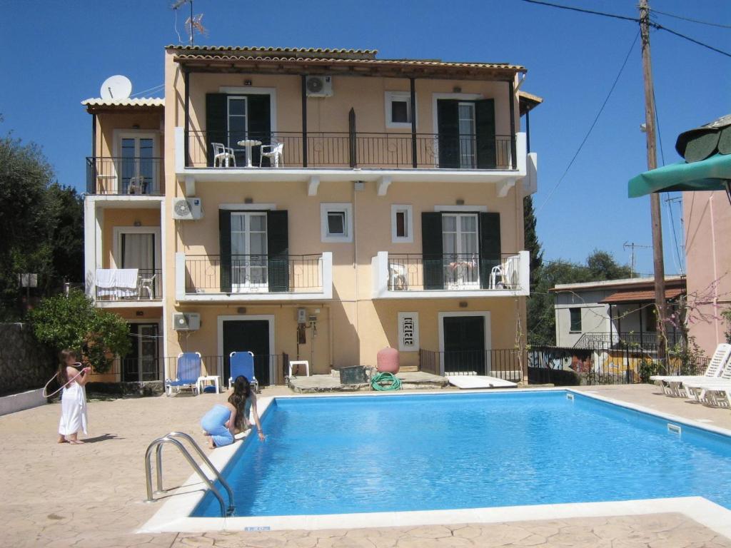 uma villa com piscina em frente a uma casa em Avgoustina Venus Studios em Benitses