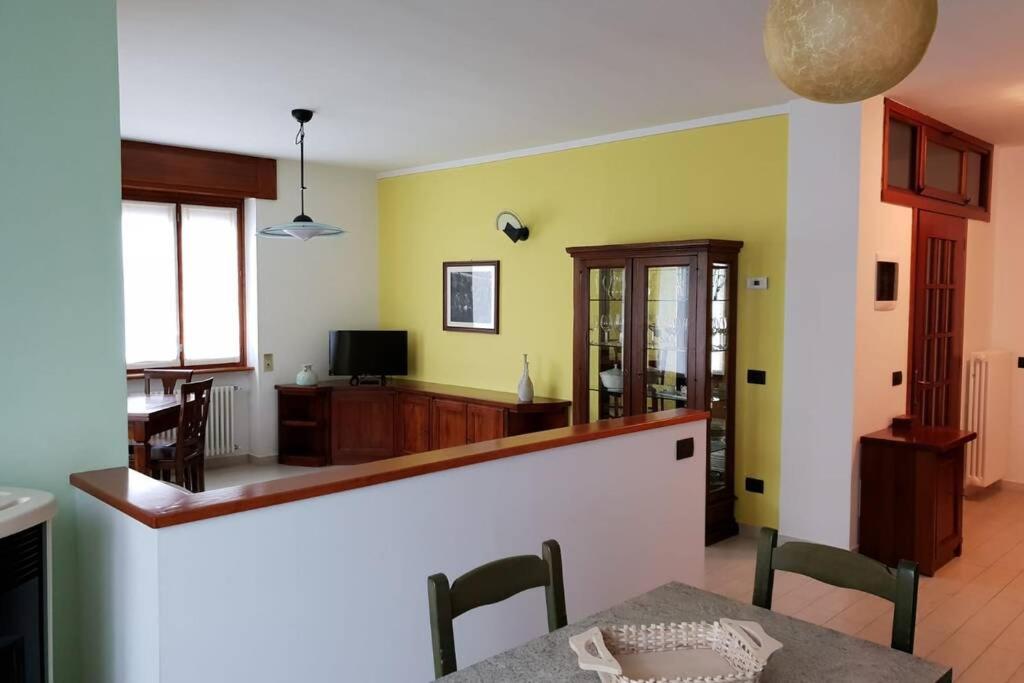 une cuisine et une salle à manger avec des murs jaunes et une table dans l'établissement Casa Bialugn, à Varzo