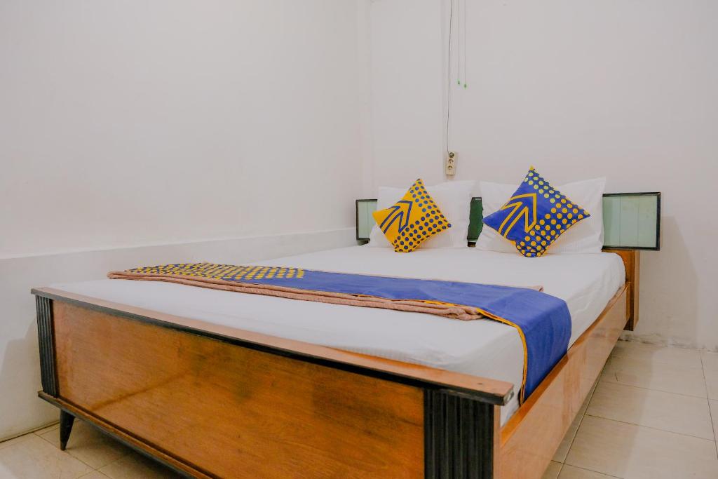 a bed with a wooden frame in a room at OYO 2417 Melati Residence in Blitar