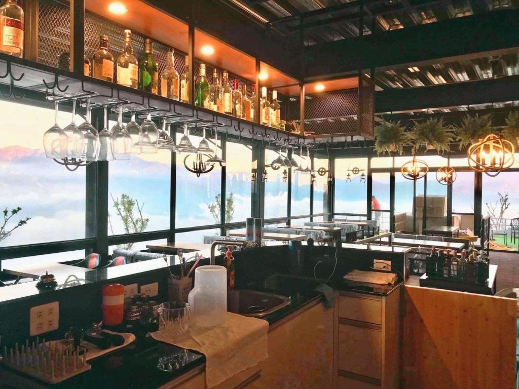 a restaurant with a bar with a view of the ocean at Starhome Cottage in Ren&#39;ai