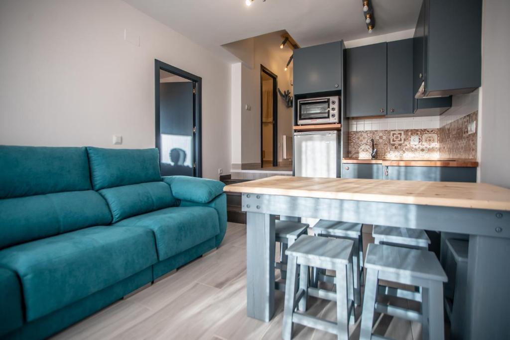 a living room with a blue couch and a kitchen at Cielo in Sierra Nevada
