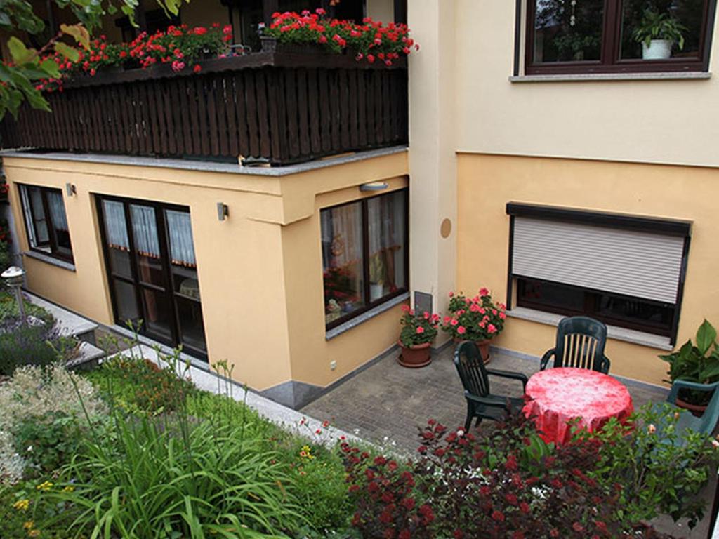 un patio con mesa y sillas frente a una casa en Ferienwohnung Noack, en Kranichfeld