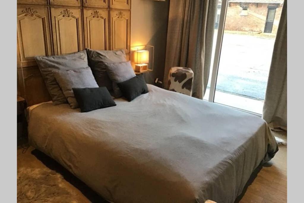 a large bed with two pillows on it in a bedroom at LA MARLIERE maison de charme à la campagne in Houthem