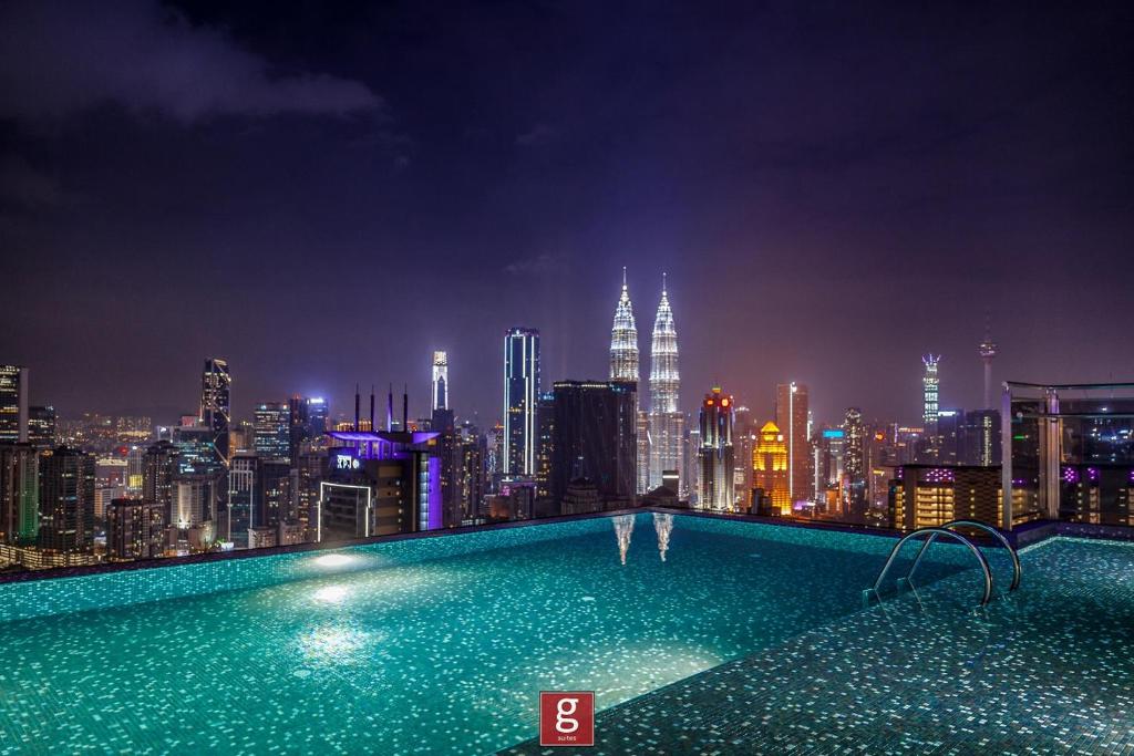 a swimming pool on top of a city skyline at night at EXPRESSIONZ KLCC by Gsuites in Kuala Lumpur