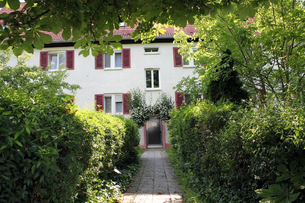 a white house with red shutters and a walkway at Ferienwohnung am Salzsee in Bad Windsheim