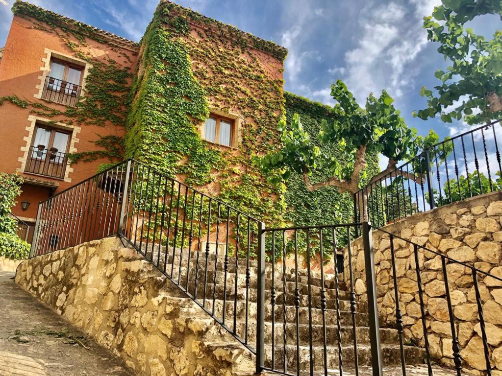 a building covered in ivy next to a fence at Molí Fariner Casa Rural in Agullent