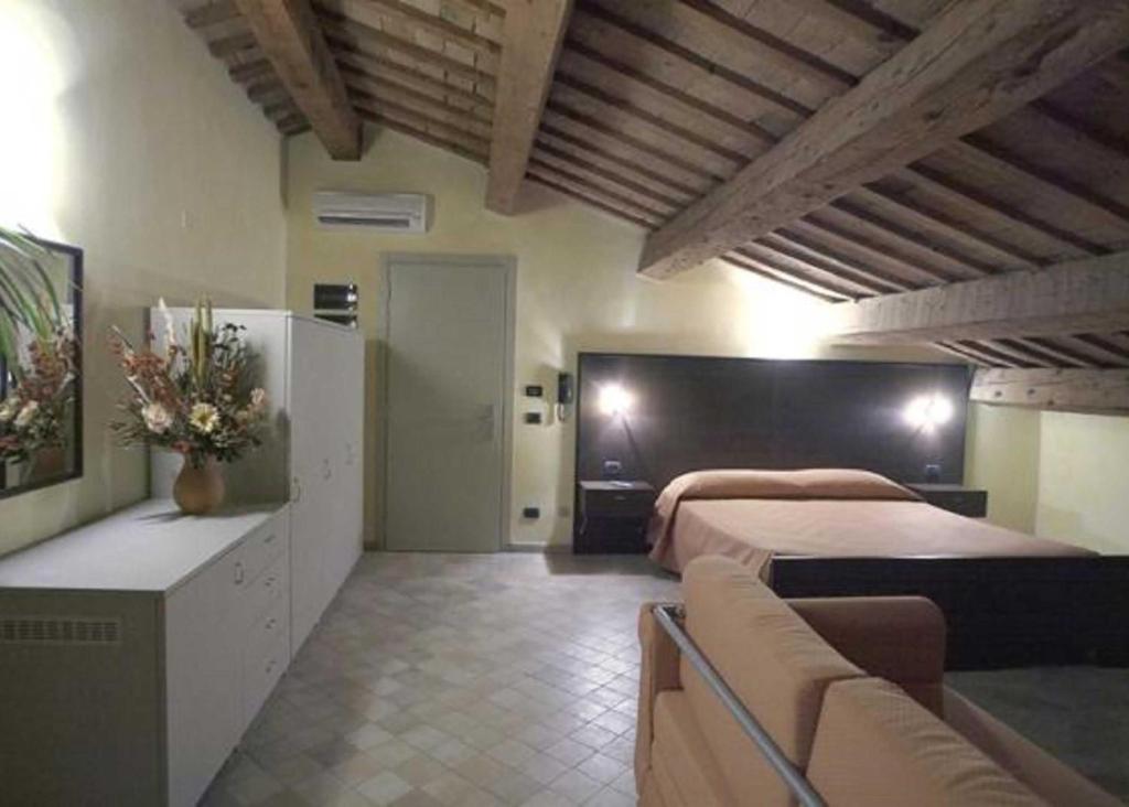 Habitación grande con 2 camas y sofá en Affittacamere Il Pagliericcio, en Ferrara