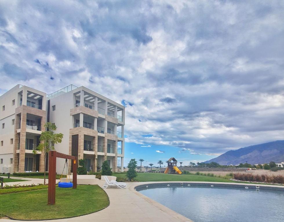 un edificio con piscina al lado de un edificio en Sifah Resort Studio, en As Sīfah