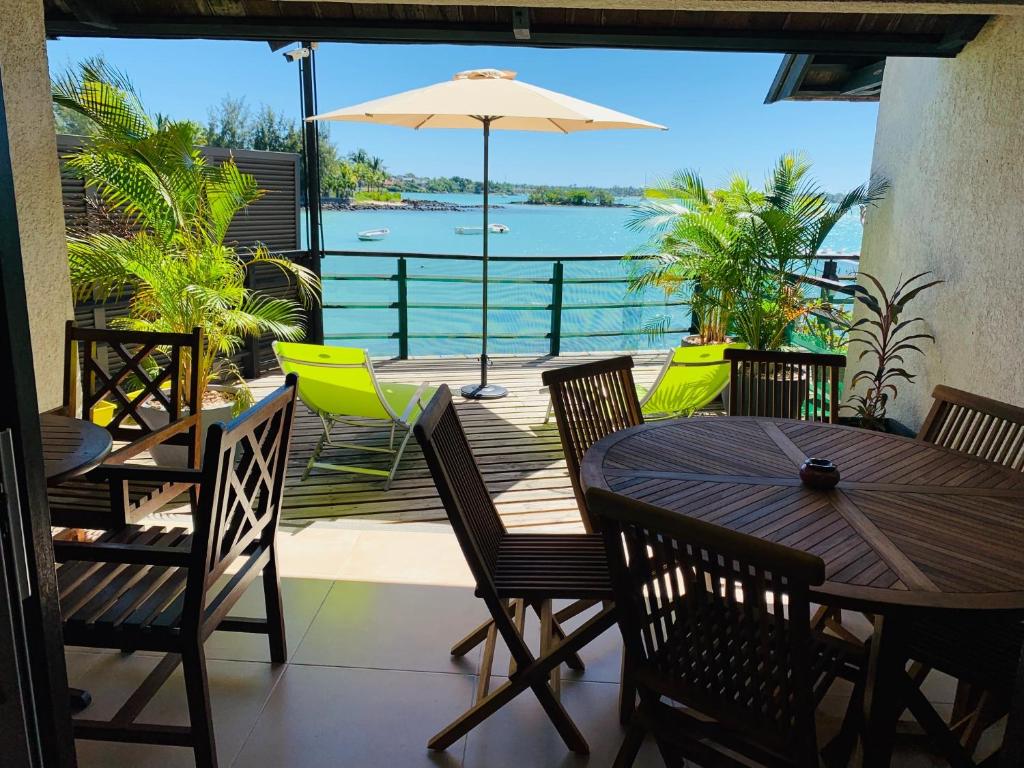 a patio with a table and chairs and a view of the water at appartement Grand Baie île Maurice in Grand-Baie