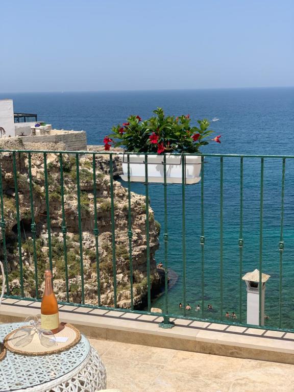 a table on a balcony with a view of the ocean at POSEA - Polignano Sea Suites in Polignano a Mare