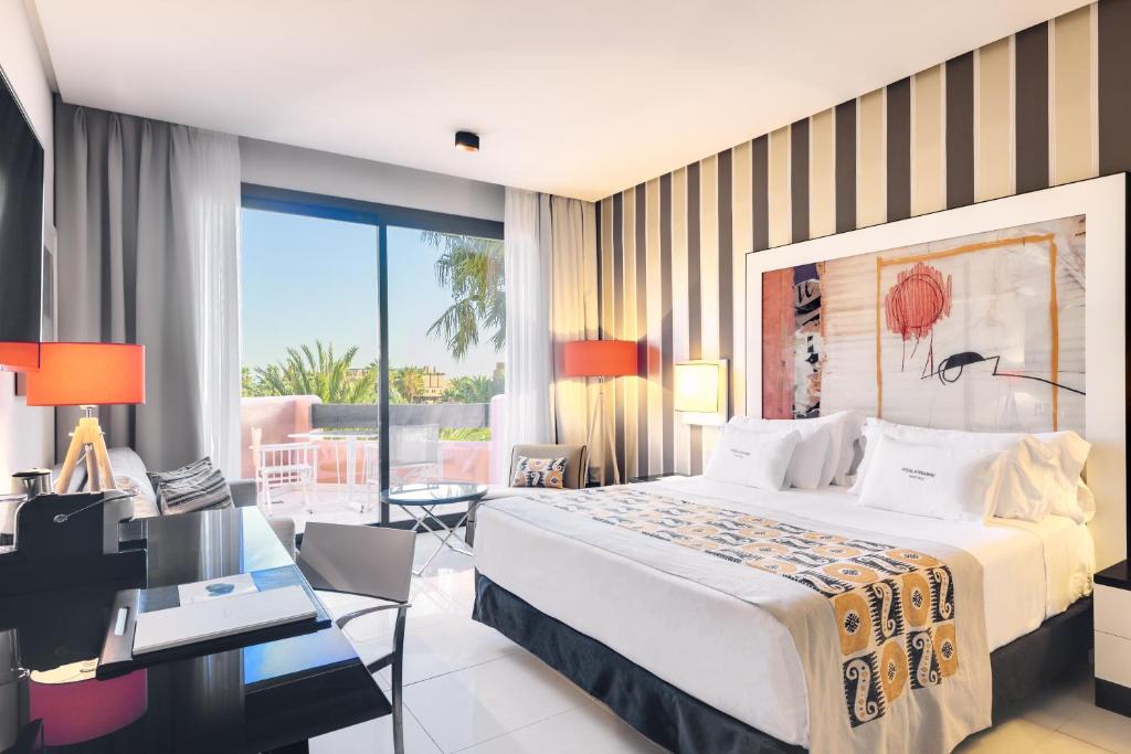 a hotel room with a large bed and a desk at Royal Hideaway Sancti Petri in Chiclana de la Frontera