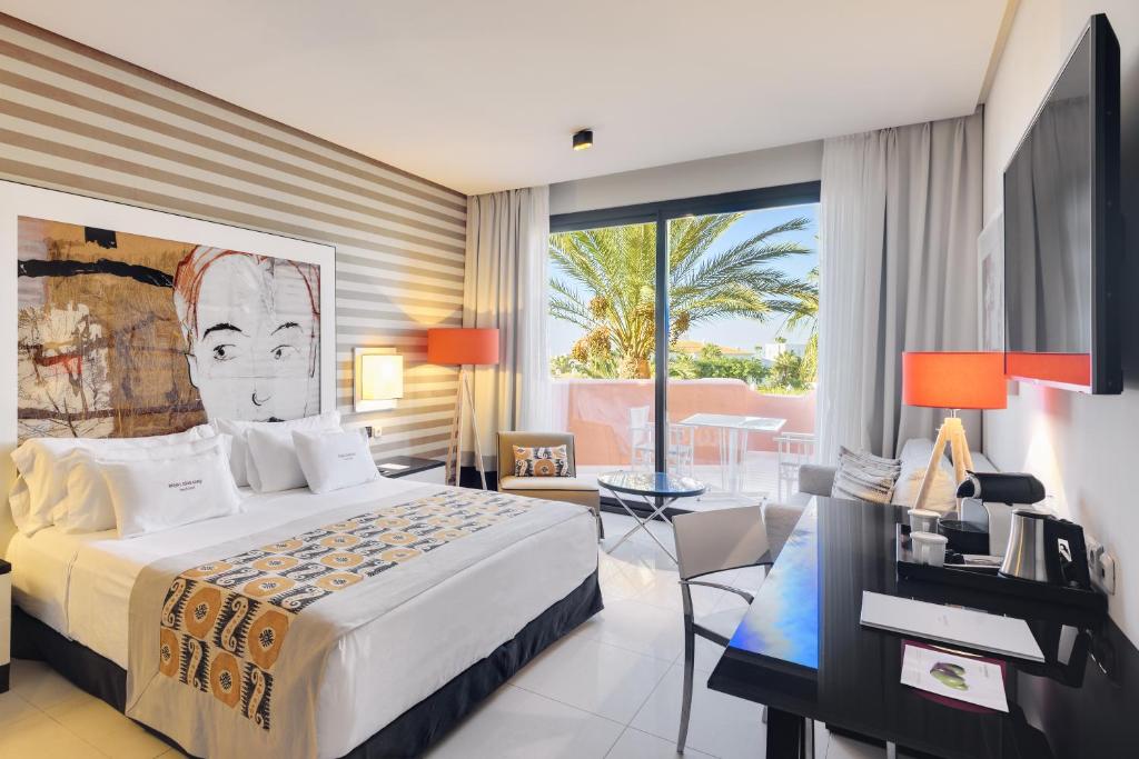 a bedroom with a large bed and a large window at Royal Hideaway Sancti Petri in Chiclana de la Frontera