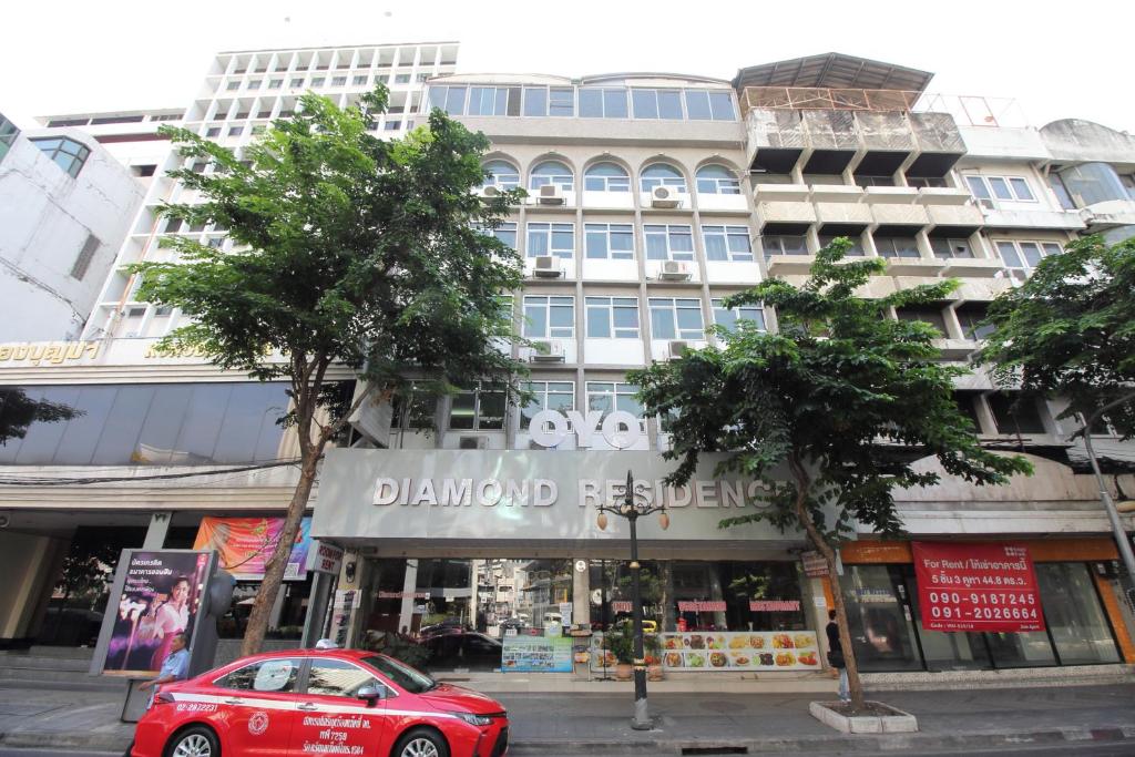 a red car parked in front of a building at OYO 102 Diamond Residence Silom in Bangkok