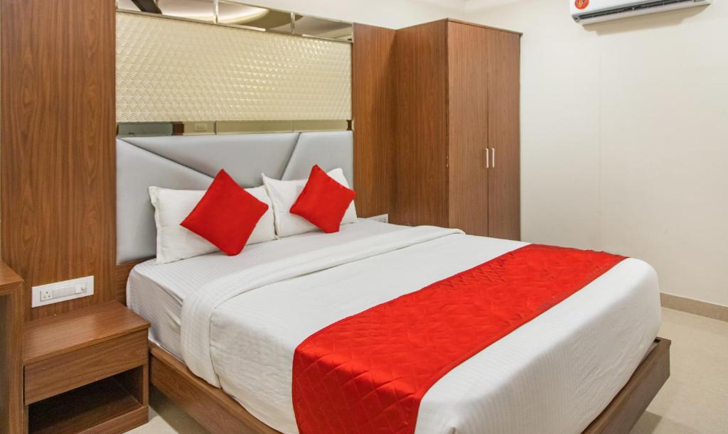 um quarto com uma cama grande e almofadas vermelhas em Hotel Hometown Near US Embassy BKC em Mumbai