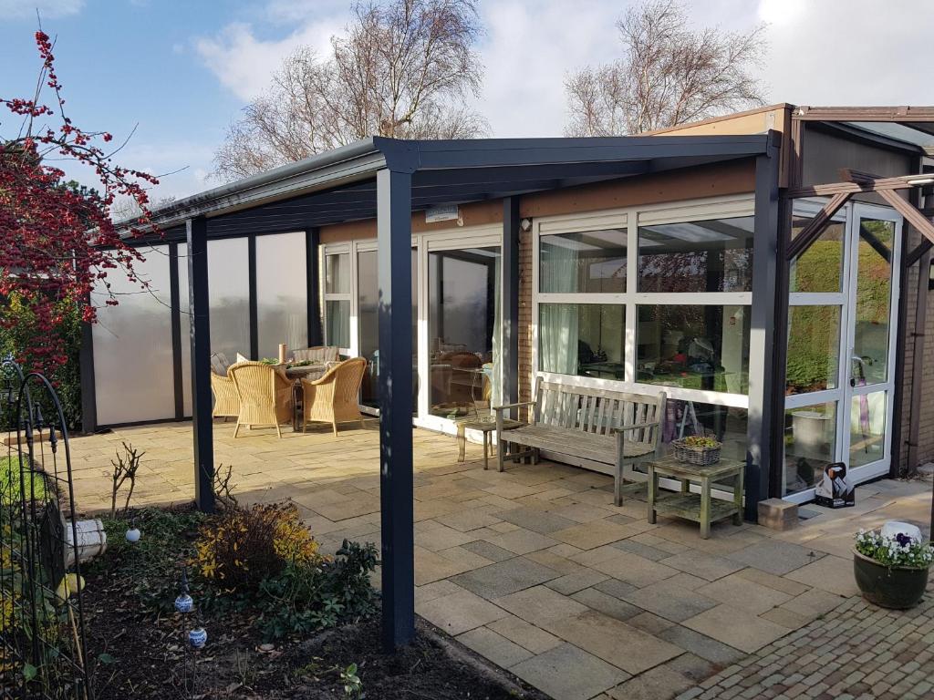 a conservatory with glass doors and a patio at Alexanderpark 5 - Ouddorp, covered terrace, near to the beach and dunes - not for companies in Ouddorp
