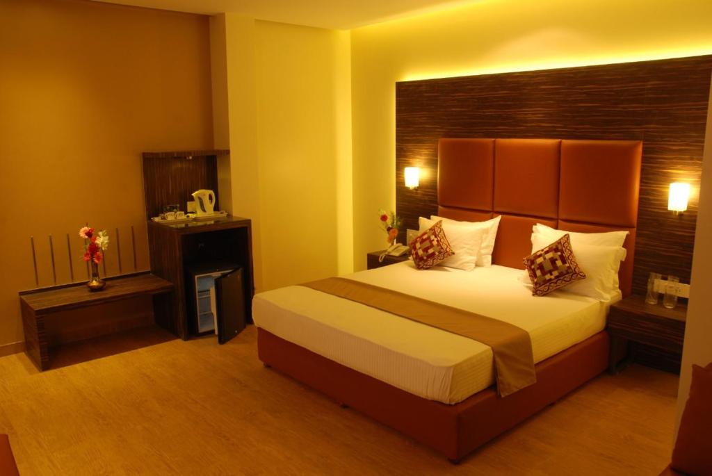 ein Schlafzimmer mit einem großen Bett in einem Hotelzimmer in der Unterkunft Hotel Rajtara in Satara