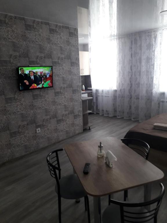 Habitación con mesa y TV en la pared. en Studio on Stefan 37 en Bălţi