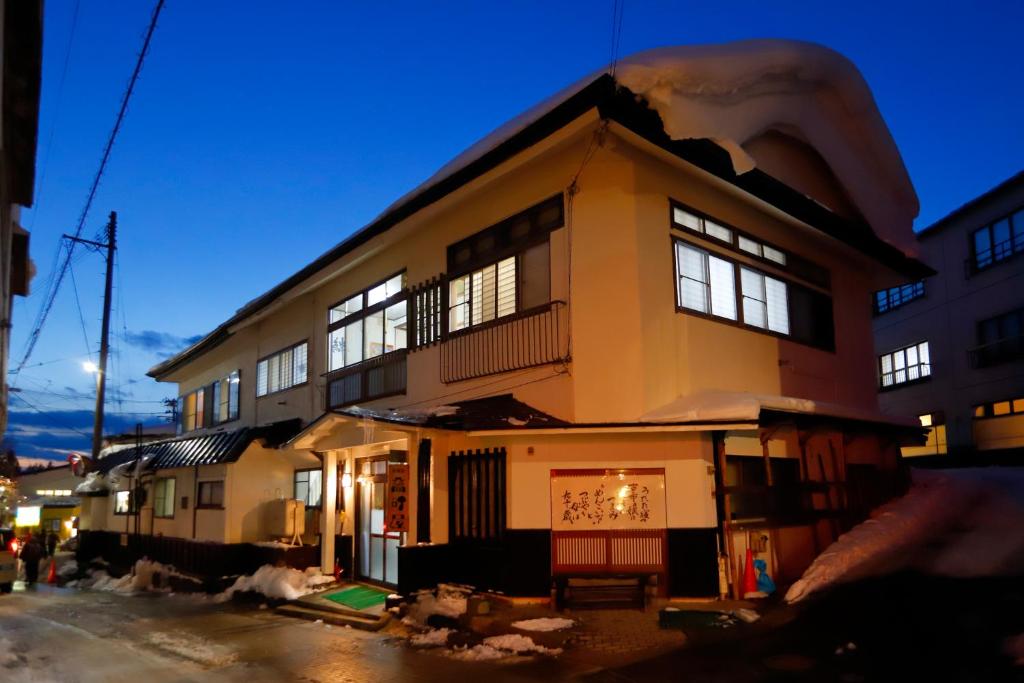 - un grand bâtiment avec des fenêtres sur le côté dans l'établissement Takasagoya Ryokan, à Zao Onsen