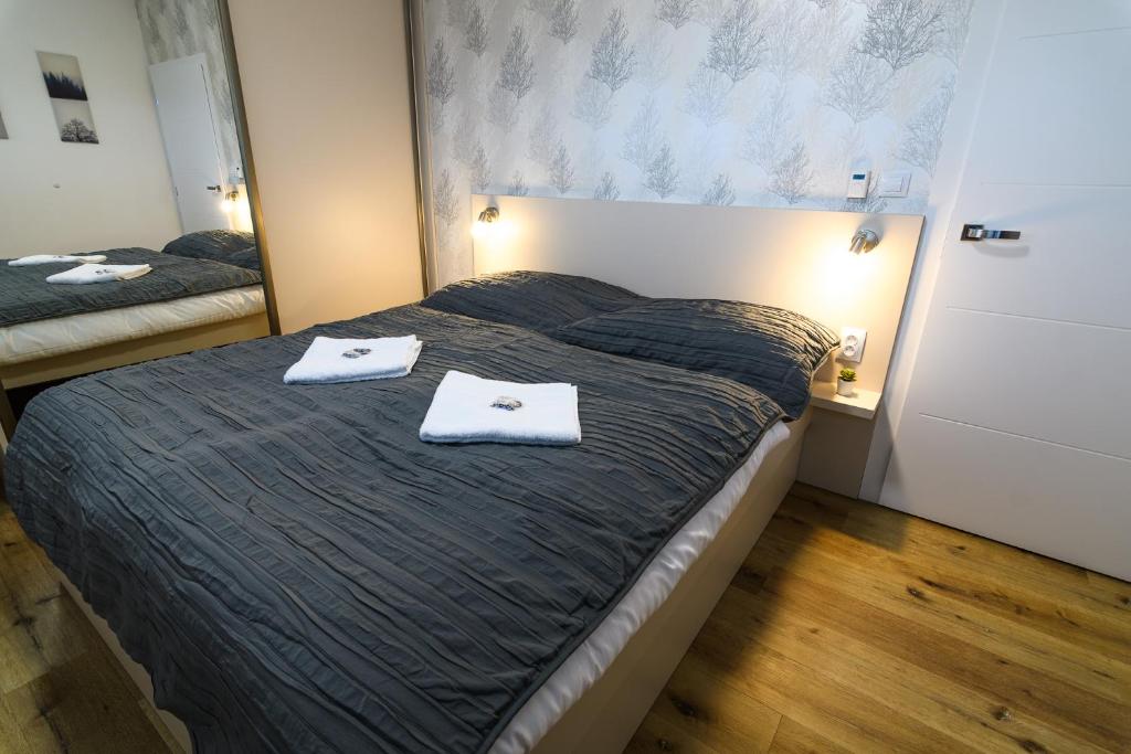 a bedroom with a bed with two towels on it at Apartmány NMNM REZIDENCE NAD MĚSTEM in Nové Město na Moravě