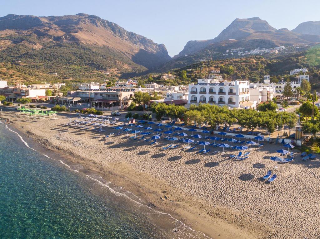 an aerial view of a beach with chairs and umbrellas at Alianthos Beach Hotel in Plakias