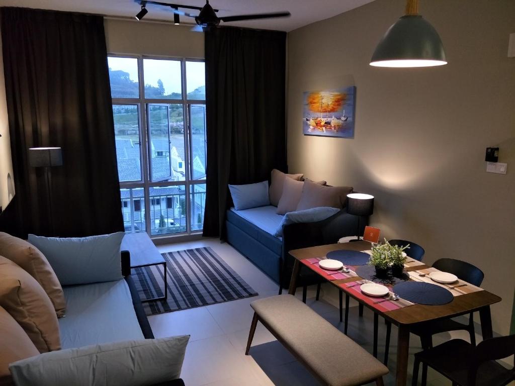 een woonkamer met een bank en een tafel bij Cameron Highlands Apartment HL in Tanah Rata