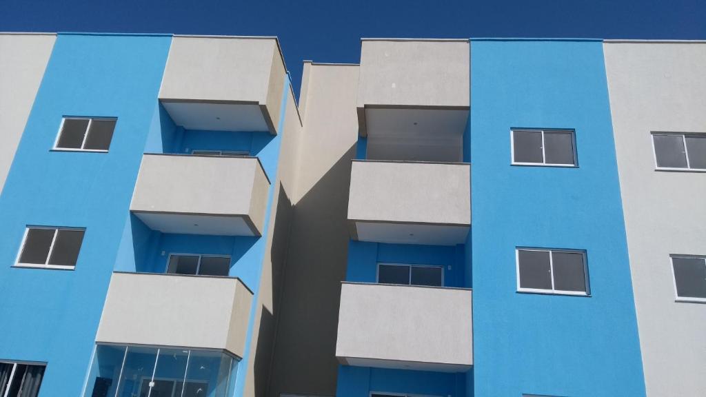 un edificio de apartamentos azul con balcones en Aquaville Atalaia Apartamentos, en Luís Correia