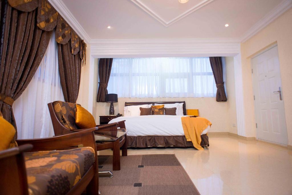 a bedroom with a bed and a large window at The Ritzz Exclusive Guest House in Accra