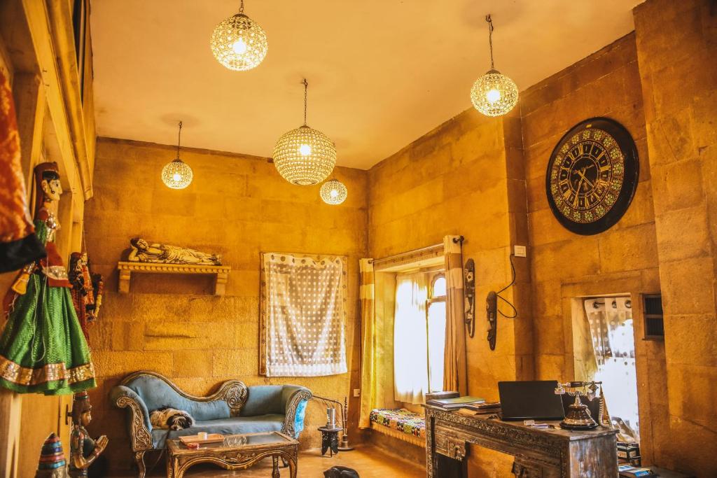 a living room with a couch and a clock on the wall at Garh Meera - A Sensational Boutique Hotel in Jaisalmer