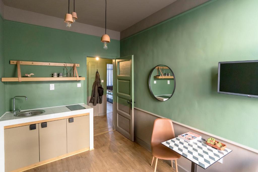 a kitchen with green walls and a sink and a mirror at Beautiful best location apartment Green Mouse in Plovdiv