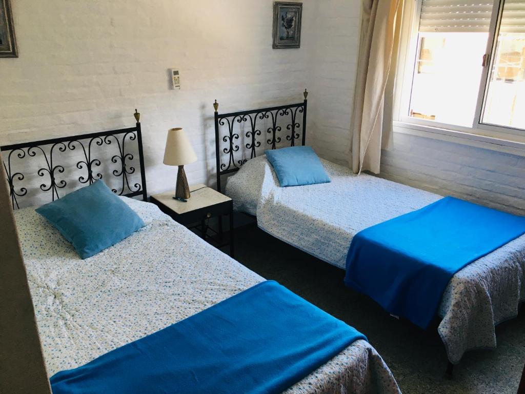 2 camas en una habitación con sábanas azules en Apto San Rafael Viña del Mar, en Punta del Este