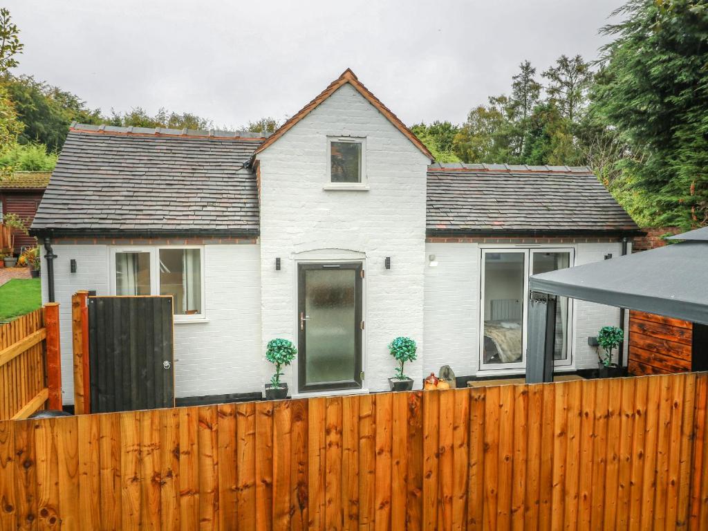 a white house behind a wooden fence at The Old Smokehouse in Rugeley