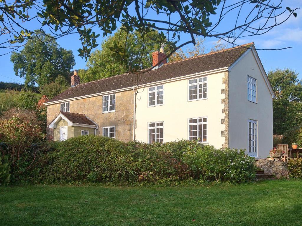 an old brick house on a hill with a yard at Church View in Tisbury