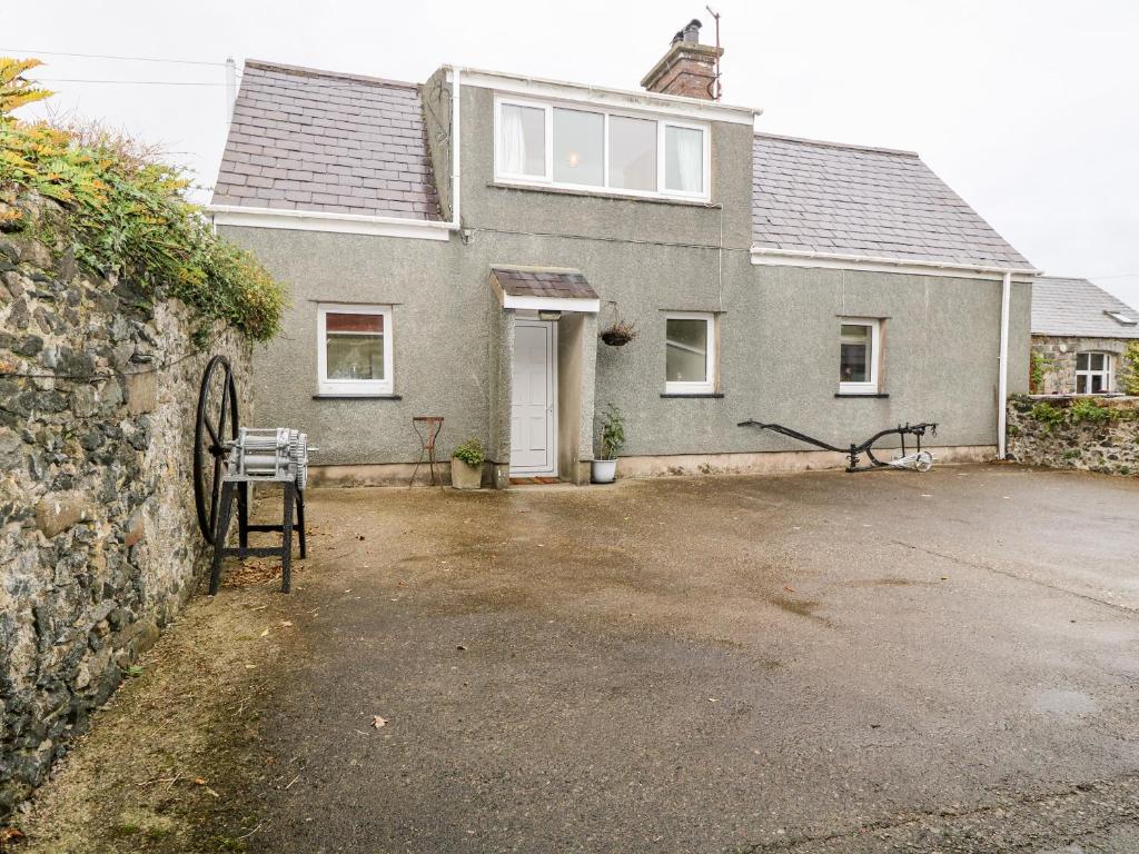 a house with a large driveway in front of it at Y Bwthyn in Pwllheli