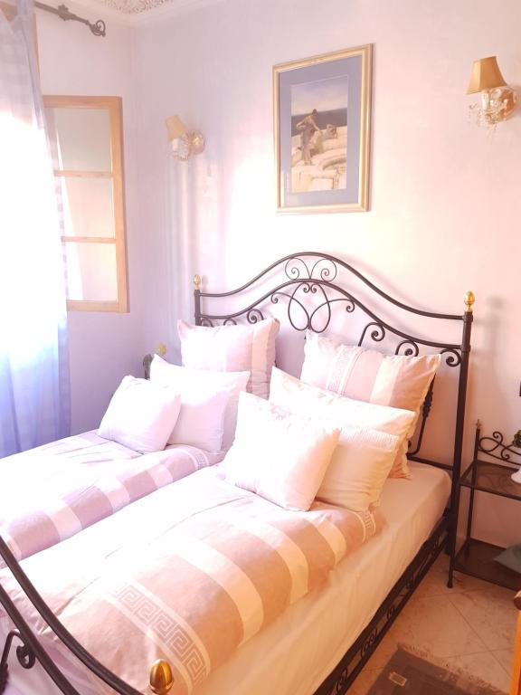 een slaapkamer met 2 bedden en witte kussens bij Appartement Andalou in Marrakesh