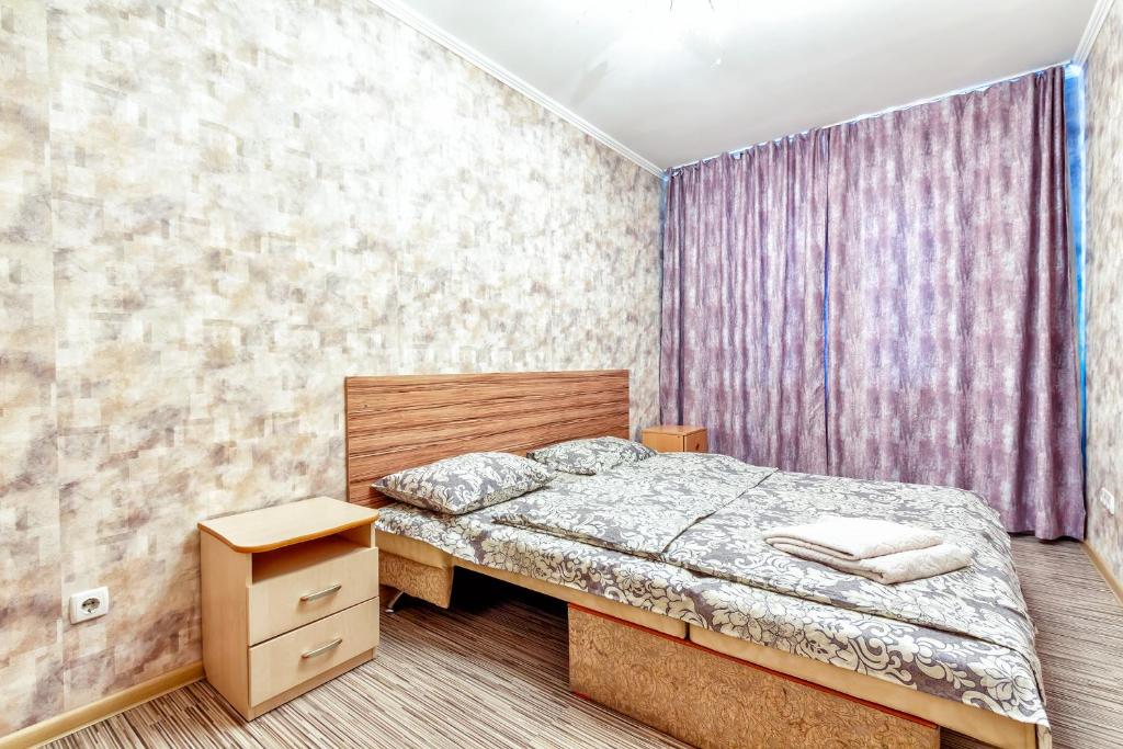 a bedroom with a bed and a purple wall at 411 Вместительные апартаменты в центре Отлично подходят для командированных и туристов in Almaty