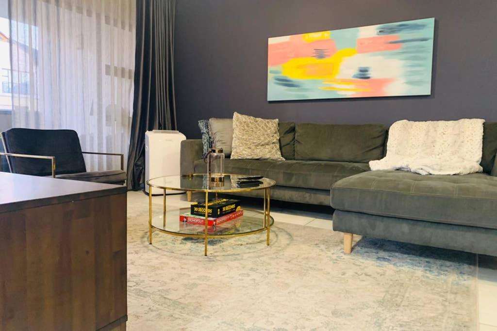 a living room with a couch and a table at Kikuyu Waterfall - 3 Bed Luxe Apartment by Ulo in Midrand