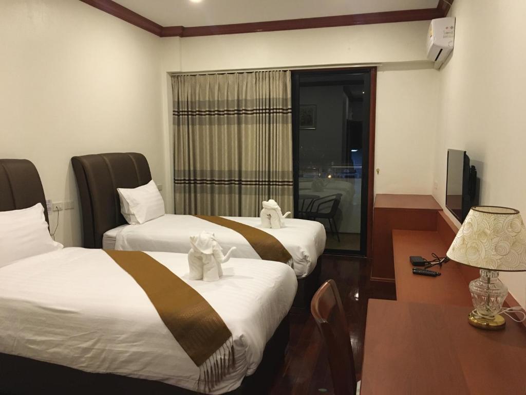 Vuode tai vuoteita majoituspaikassa Nakhone Champa Hotel