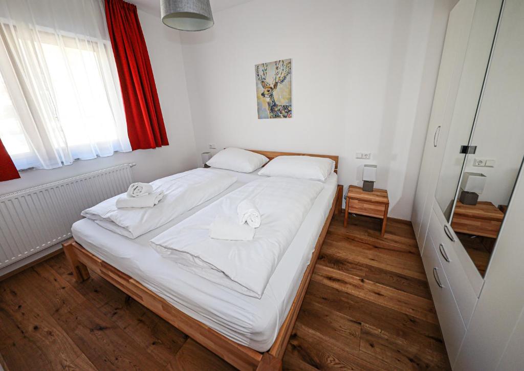 A bed or beds in a room at Appartementhaus Römerhof Superior - Kärnten Card Sommer inklusive
