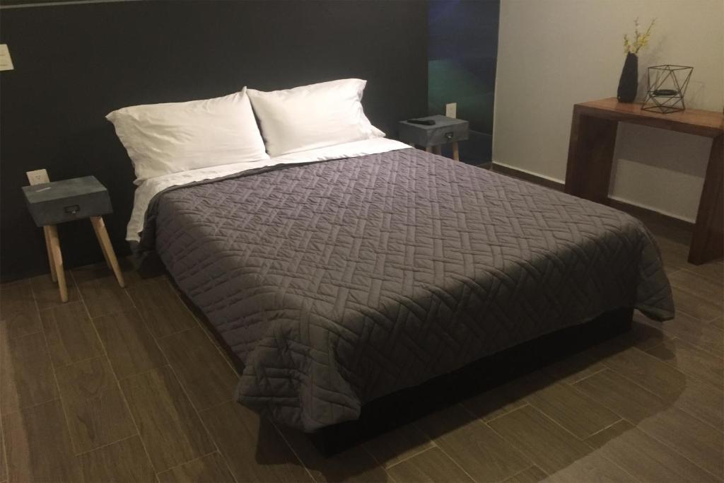 um quarto com uma cama grande e almofadas brancas em Coaranda Hotel Boutique em Arandas