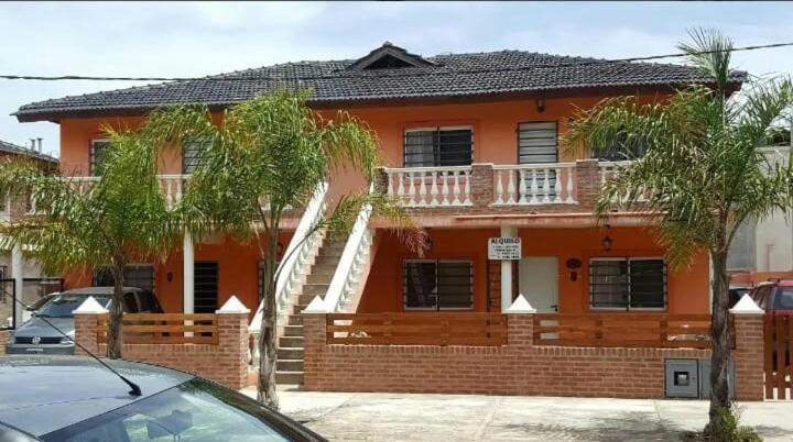 a orange house with a balcony on the front of it at Complejo Los Cuervos in San Clemente del Tuyú
