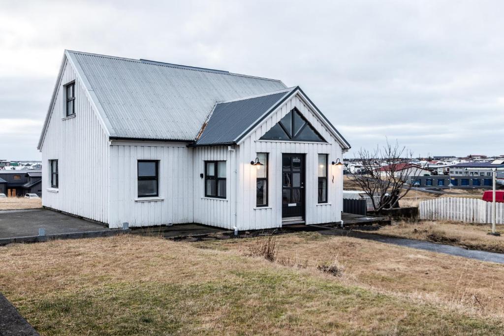 a white house with a gray roof at GreenKey House B16 in Keflavík