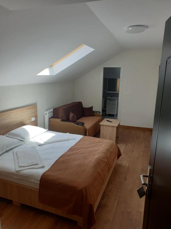 Un dormitorio con una cama grande y un sofá. en Casa Patricia, en Lupeni