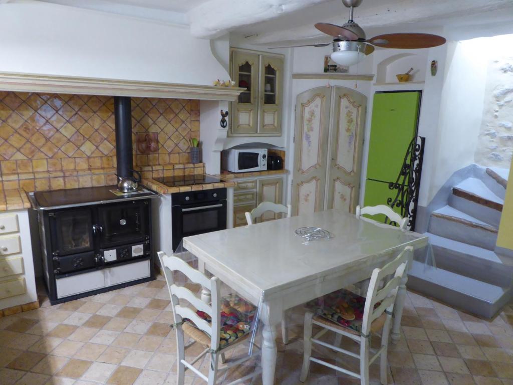 eine Küche mit einem weißen Tisch und Stühlen in der Unterkunft La Jubilotte in Beaumes-de-Venise