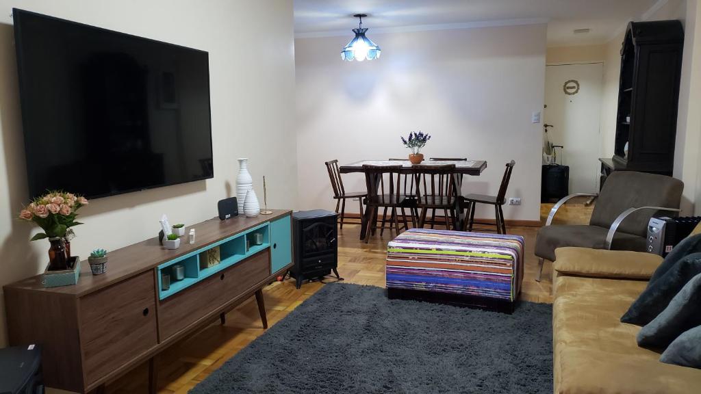 a living room with a large flat screen tv at Apartamento no Capivari com Elevador in Campos do Jordão