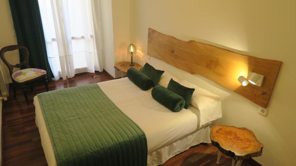 een slaapkamer met een groot bed met groene kussens bij Apartamentos Palacio Azcárate Travesía Calvario in Ezcaray