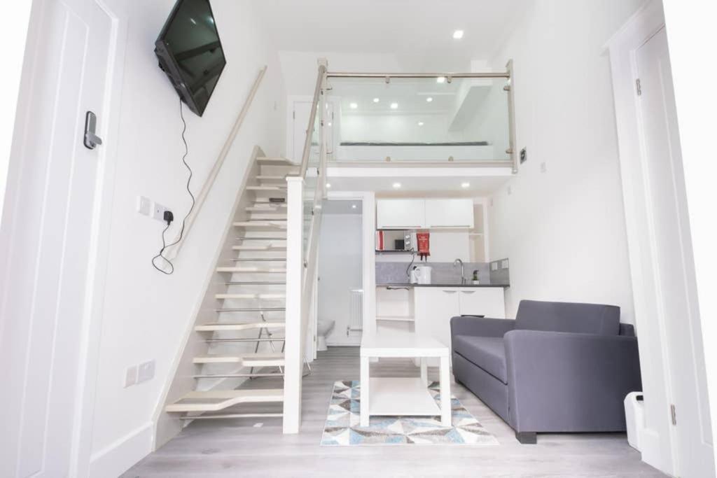 a living room with a staircase and a couch at Quirky, Stylish & Modern Studio in Central Reading in London