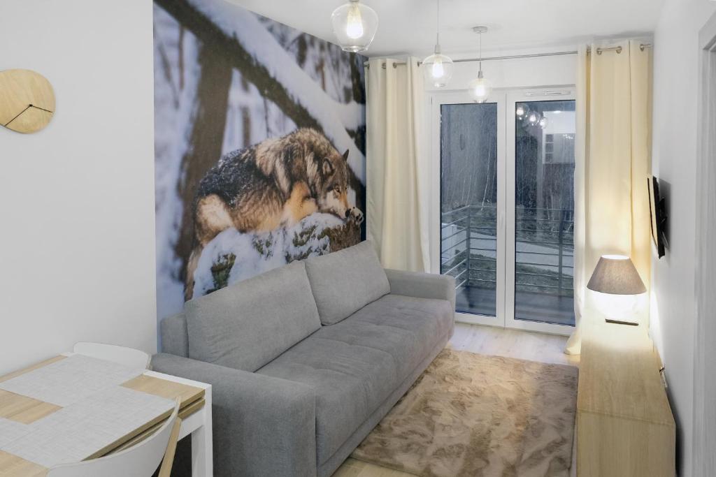 a living room with a couch and a dog on the wall at Apartament Szary Wilk in Świeradów-Zdrój