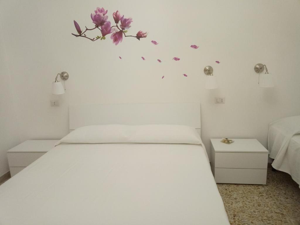 a bedroom with a bed with flowers on the wall at Belvedere di San Benedetto del Tronto affittacamere senza colazione in San Benedetto del Tronto